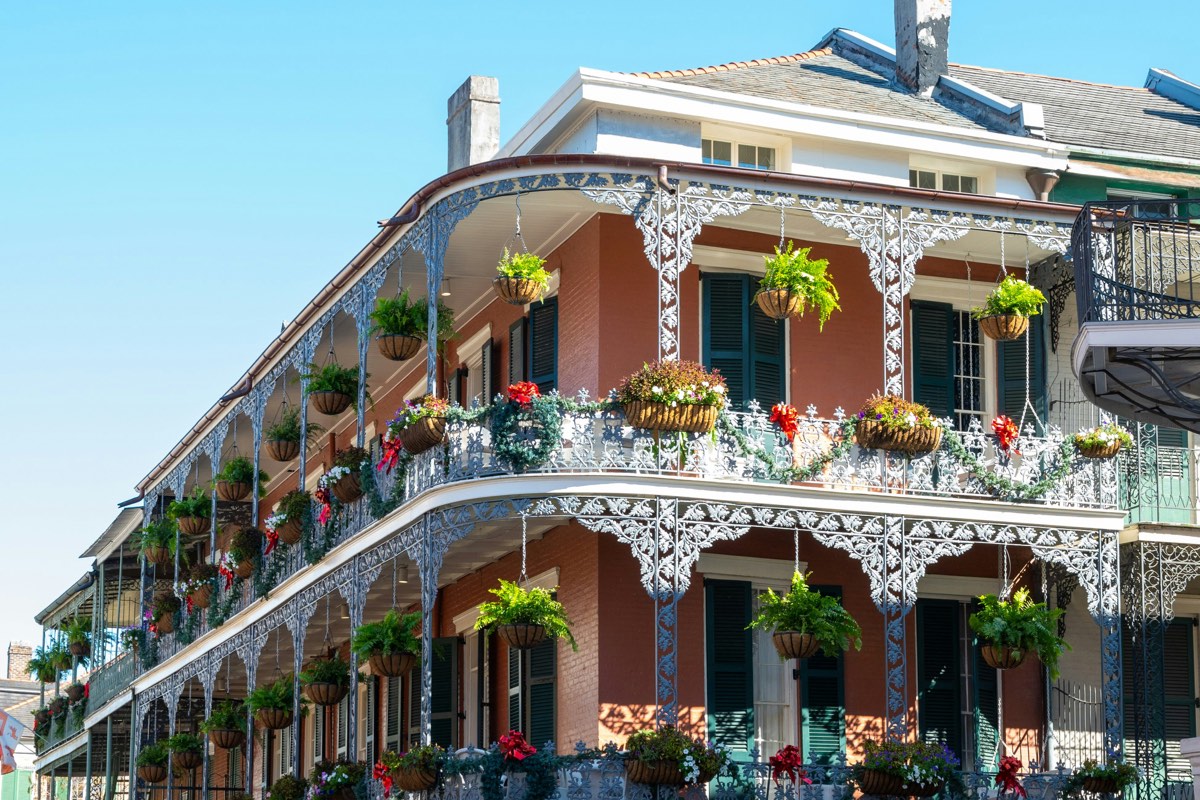 Ornate cast-iron galleries with hanging ferns on a French Quarter building in New Orleans